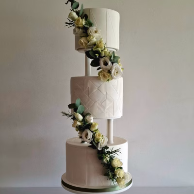 Geometric panels of fondant texture the surface of three tiered wedding cake fresh flower decoration retro wedding cake pillar seperators
